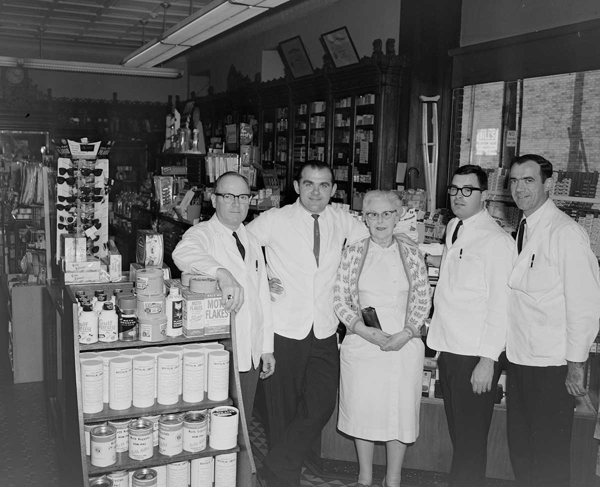 People standing in old pharmacy